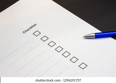 View of a checklist with selection boxes and blue pen against black background