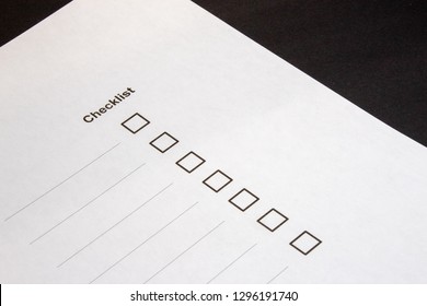 View of a checklist with selection boxes and blue pen against black background