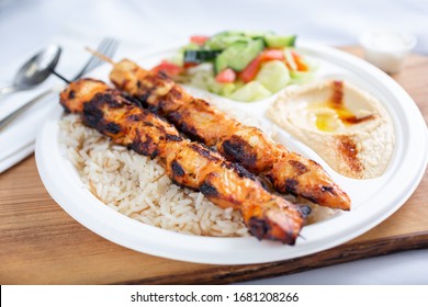 A View Of A Chicken Kabob Plate Over Rice.