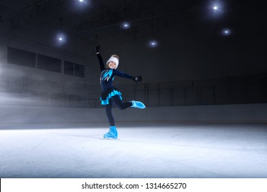 View Of Child  Figure Skater On Dark Ice Arena Background