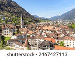 View of Chur old town surrounded by towering mountains on a sunny spring morning