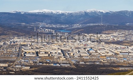 View of the city of Magadan. Panorama of a large northern city in a valley among the mountains. Beautiful autumn cityscape. Street and building view. Magadan, Magadan region, Siberia, Far East Russia.