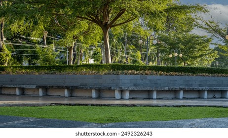 view of the city park with concrete benches and lights, beautiful and beautiful garden with big trees and bonsai city park. Environmental care theme background concept - Powered by Shutterstock