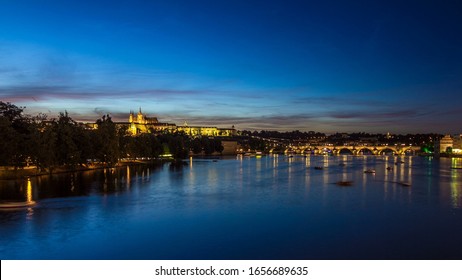 View Of The City Prague In Czech Republic With Colorful Paddle Boats Day To Night Transition Timelapse On The Vltava River With Beautiful Sky. Charles Bridge On Background