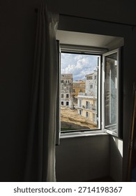 View of Cityscape Through Open Window
