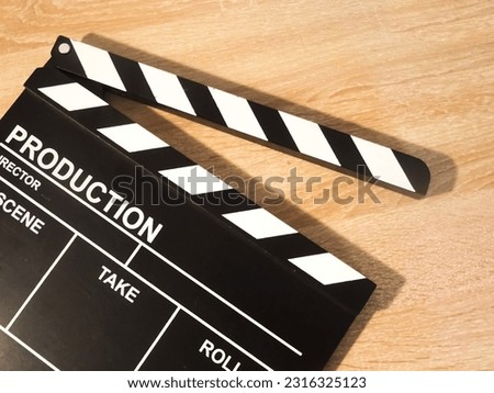 View of a clapperboard on a wooden background. Concept of video production, series, movies, films, feature films, film industry.