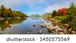 View of the clear water, stones and fall foliage of Jordan Pond in Acadia National Park