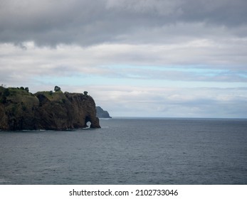 view of the cliff with a hole at the bottom, ocean waves hitting the cliff, postcard view Ponta Delgada Azores Portugal October 2021