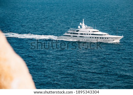 View from a cliff of a yacht crossing the sea. Copy space.