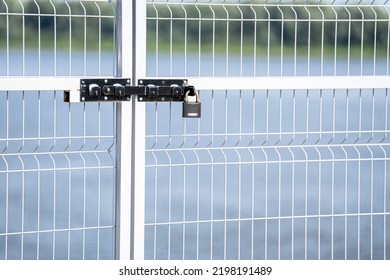 View of the closed latticed elegant modern gates with a rack and padlock. Close-up