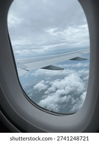 View of clouds from the airplane window during flight. Concepts of travel, vacation, transportation, and flying.