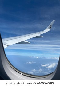 View of clouds from the airplane window during flight. Concepts of travel, vacation, transportation, and flying.