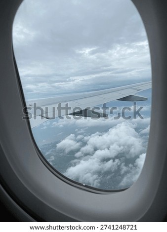 View of clouds from the airplane window during flight. Concepts of travel, vacation, transportation, and flying.