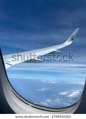 View of clouds from the airplane window during flight. Concepts of travel, vacation, transportation, and flying.