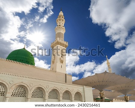 View of cloudy blue sky with shining sun at Nabawi Mosque or Prophet Mosque in Medina, Saudi Arabia. Selective focus