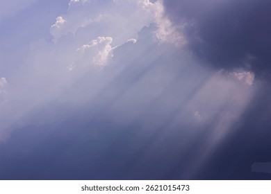 View of cloudy sky with dramatic sunlight rays shining through. Represents weather, atmosphere, and abstract light.


