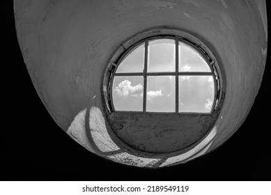 View of the cloudy sky  through a round circular window.