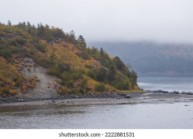 View Of The Coast Of The Island In The Sea Bay. Autumn Seascape. Overcast Weather. Low Clouds. Nature Of Siberia And The Russian Far East. Gertner Bay, Sea Of Okhotsk, Magadan Region, Russia.