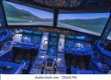 A view of the cockpit of a large commercial airplane, a cockpit trainer. Cockpit view of a commercial jaircraft cruising - Shutterstock ID 720141796