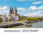 view of Cologne Cathedral and the Hohenzollern Bridge. The Gothic architecture of the cathedral contrasts beautifully with the iconic steel structure of the bridge.