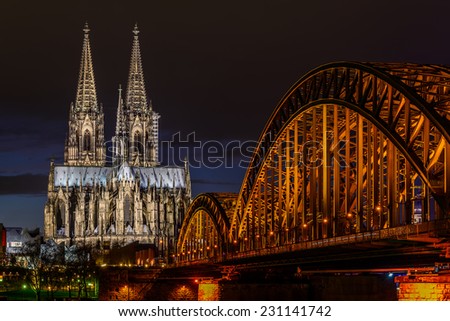 View of the Cologne Cathedral and Hohenzollern Bridge across the Rhine, Germany, at dusk