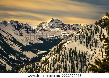View of Colorado Mountain range at sunset; Maroon Bells peaks in background