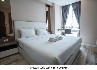 View of comfortable Queen size bed in hotel bedroom decoration in cozy style. Conceptual of a room in a home where people sleep.