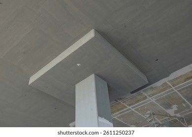 View of a concrete structural column supporting a ceiling slab, showcasing the durability and design of modern construction techniques.