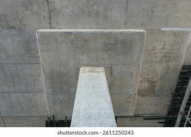 View of a concrete structural column supporting a ceiling slab, showcasing the durability and design of modern construction techniques.