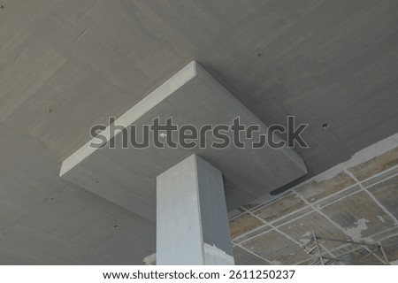 View of a concrete structural column supporting a ceiling slab, showcasing the durability and design of modern construction techniques.