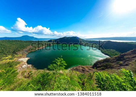 View of cones of Taal Volcano and the wind ruffled emerald green water in the Lake Taal on a sunny day in Tagaytay, Philippines.