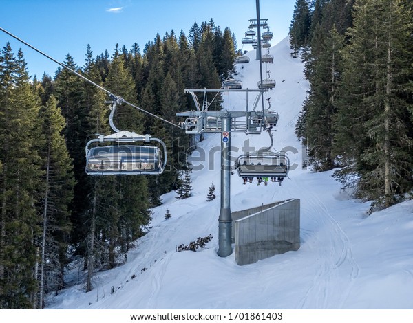 View of coniferous forest and\
mountains from a chair lift. View of a ski resort piste and\
Dolomites mountains in Italy from Passo Pordoi pass. Arabba,\
Italy