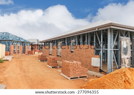 view of construction site with homes from brick with metal framing against a blue sky