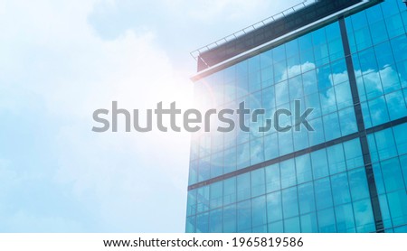 view of a contemporary glass skyscraper reflecting the blue sky. skyscrapers in a finance district from a low angle. High rise skyscrapers. Workers working late. Contemporary office building ,blue sky