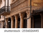 View of the Corinthian columns in the portico of the historic Casa del Mercante, built in 1455, exhibiting a harmonious blend of Gothic and Renaissance architecture, Mantua