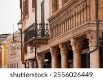 View of the Corinthian columns in the portico of the historic Casa del Mercante, built in 1455, exhibiting a harmonious blend of Gothic and Renaissance architecture, Mantua