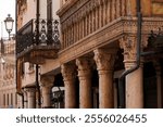 View of the Corinthian columns in the portico of the historic Casa del Mercante, built in 1455, exhibiting a harmonious blend of Gothic and Renaissance architecture, Mantua