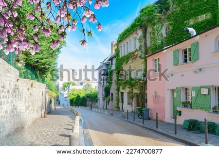 View of cosy street in quarter Montmartre in Paris, France. Cozy cityscape of Paris at summer. Architecture and landmarks of Paris.
