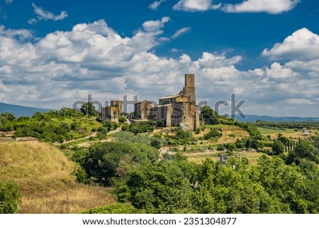 A view of the countryside around the medieval village of Tuscania (city of the Etruscans), in the province of Viterbo, Lazio. On top of a hill stands the ancient Romanesque church of San Pietro.