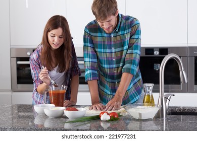 View Of Couple Making Pizza At Home