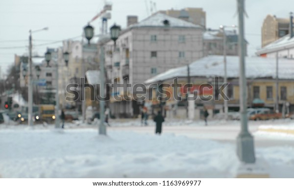 View of the crossroad in the city with\
cars and pedestrians. Winter view to the city.\
Blur.