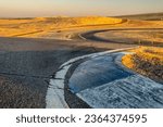 A view of a curved dirt road illuminated by the rising sun in Thunderhill Raceway Park, CA