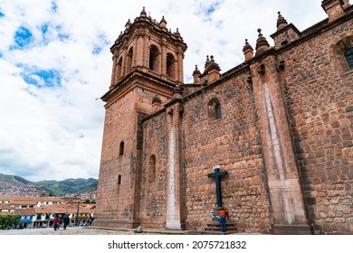 View of Cusco and the Cusco Cathedral. Brick wall and the black cross of the Cusco Cathedral or Cathedral of Santo Domingo or The Cathedral Basillica of the Assumption of the Vergin in Cusco, Peru
