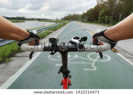 View of cyclists arms on a folding bicycle. The concept of hands on a bicycle steering wheel.