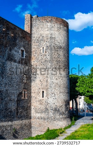 View of cylindrical corner tower (30m high) with narrow windows on Castello Ursino, built 1239-1250, Catania, Sicily, Italy (92 chars).