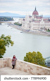 View Of Danube River And Parliament Building In Budapest And Turist Girl Stands On The Observation Deck. Hungary. Blurred Background