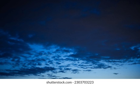 View of dark blue cloudy sky before rain during dusk, fading light, transition from blue hour to night