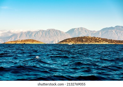 	
View of the dark blue wavy sea and mountian range. Evening.	