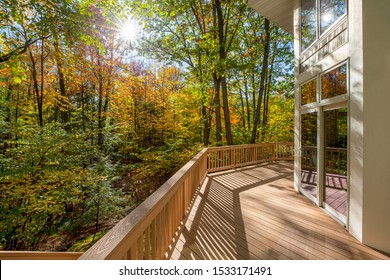 View From The Deck Of A Luxury Home In The Autumn Woods.  Outdoor Living Concept, Bright Fall Foliage, And Intentional Sun Flare Highlight.