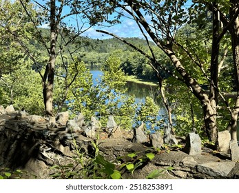 View of the Delaware River through a row of sharp spiked rocks embedded in an old stone wall next to Route 611 in the Delaware Water Gap National Recreation Area in Pennsylvania, USA